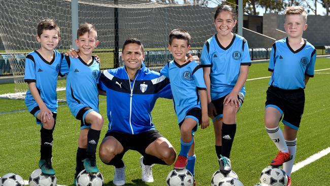 Ex-Adelaide United star Marcelo Carrusca, pictured with Luca Ventura, 8, Luca Radice, 8, Benjamin Romero Victorica, 7, Georgia Ventura, 10 and Edin Mulabecirovic, 8 from his soccer academy, sustained calf tightness during West Adelaide’s FFA Cup loss. Picture: Naomi Jellicoe