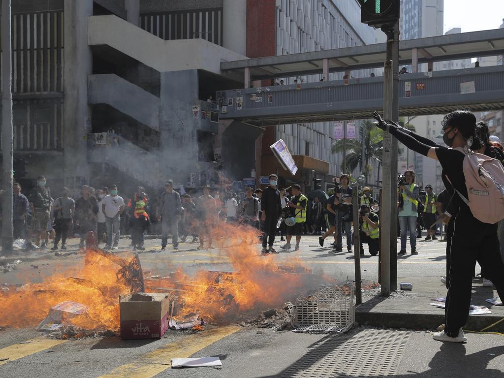 Protesters burn debris to block a road. Picture: Kin Cheung/AP