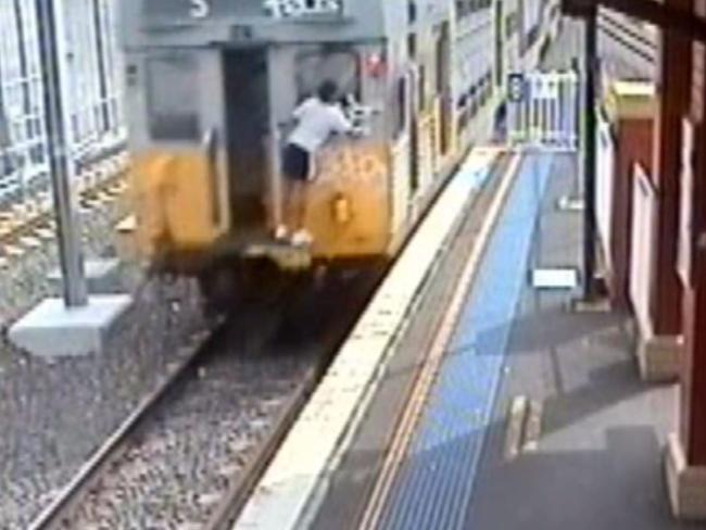 A teen in caught on CCTV riding on the back of a train.