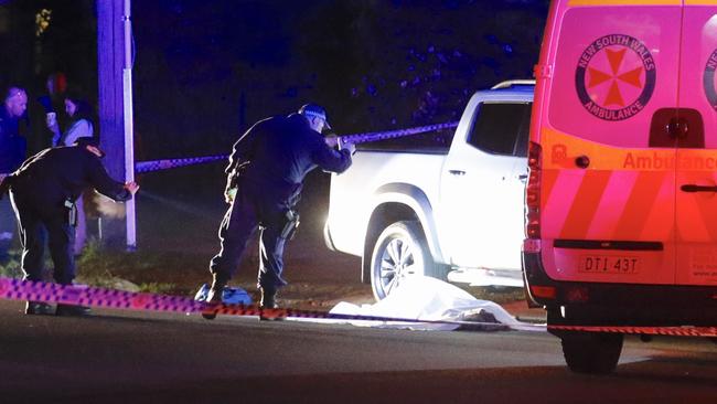 Officers investigate the scene where a man was shot dead in Panania. Picture: Steve Tyson