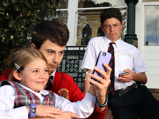 06/08/2018: Michal Brenchley with her children, Piper, 6, Finlay, 13 and Bailey,15 on their phones in Manly. New figures suggest young people are addicted to their phones, and that social media is making them anxious, which is likely to feed calls for mobile phones to be banned in schools.Pic by James Croucher