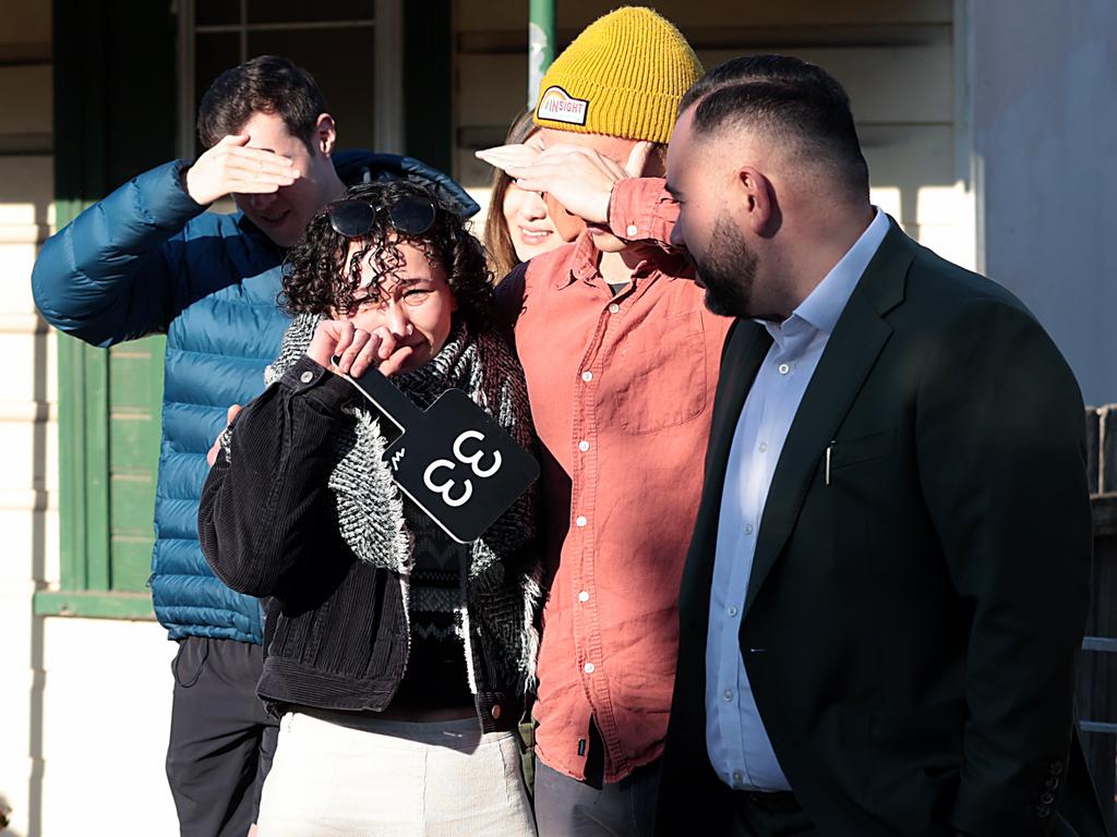 Young first homebuyer Lara Hirsch (28), comforted by her partner Sam McMahon, at an auction in Tempe. Picture: Jane Dempster