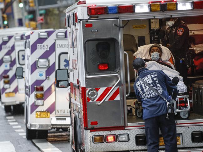 A patient arrives in an ambulance cared for by medical workers wearing personal protective equipment due to COVID-19 concerns. Picture: AP