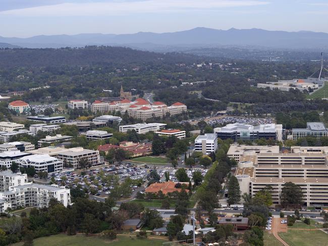 View of Canberra aerial, buildings and trees, parliament House in background and Edmond barton building in foreground.