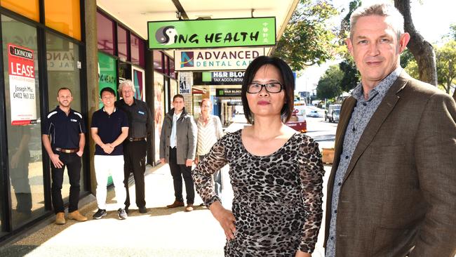 Lily Zheng and Mark Williams with some shop owners in Mount Gravatt Central. Picture: AAP/John Gass