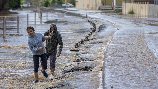 Rochester locals make their way through flooded streets. Picture: Jason Edwards