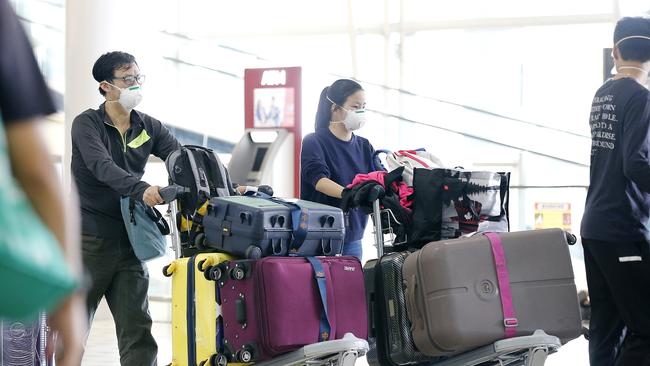 Passengers pictured arriving to Australia on flights from China and Hong Kong wearing masks. Picture: Josh Woning.