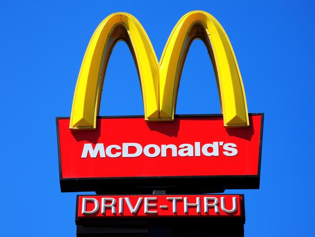 London, United Kingdom, May 27, 2012 : McDonald's yellow and red drive-thru logo advertising sign placed on a pole with a clear blue sky