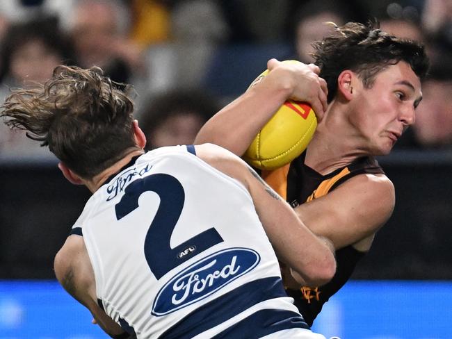 GEELONG, AUSTRALIA - JULY 06: Connor Macdonald of the Hawks breaks a tackle attempt from Zach Tuohy of the Cats during the round 17 AFL match between Geelong Cats and Hawthorn Hawks at GMHBA Stadium, on July 06, 2024, in Geelong, Australia. (Photo by Daniel Pockett/Getty Images)