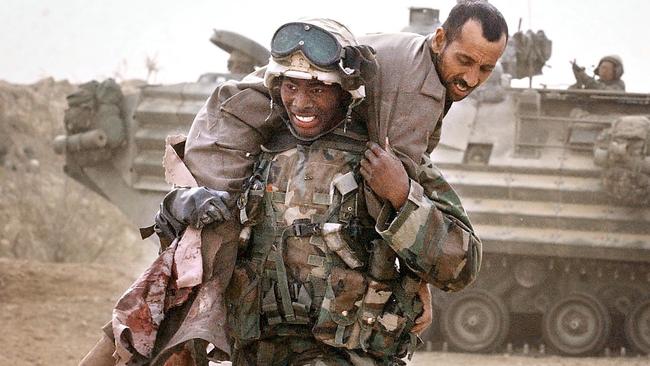 A US Marine carries an injured Iraqi soldier in 2003. Picture: AP