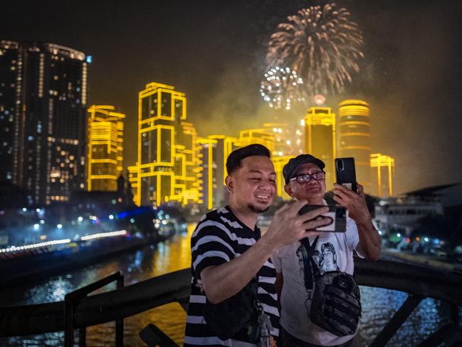 People take pictures as fireworks explode over skyscrapers during New Year celebrations on January 01, 2025 in Makati, Metro Manila, Philippines. Picture: Ezra Acayan/Getty Images