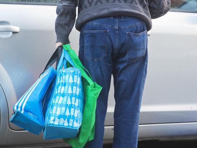 SYDNEY, AUSTRALIA - MARCH 17:  A man arrives with his shopping bags at Woolworths supermarket in Balmain on March 17, 2020 in Sydney, Australia. Woolworths Supermarkets opened exclusively for the elderly and those with a disability to shop from 7am to 8am as COVID-19 cases and fears grow.  (Photo by Jenny Evans/Getty Images)