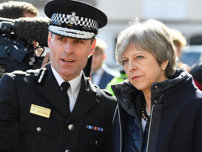 British Prime Minister Theresa May speaks with an officer as she visits Salisbury after the attack.