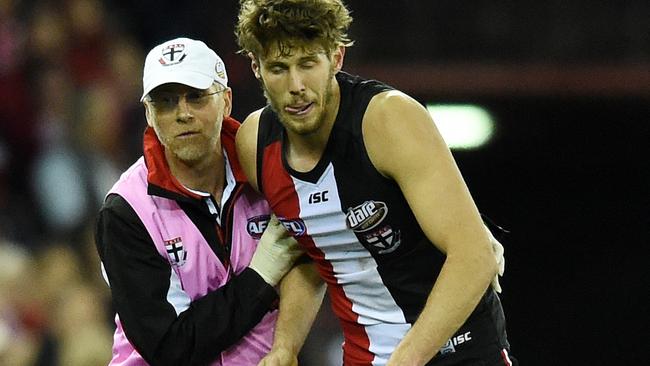 Tom Hickey is helped from the field against Sydney.