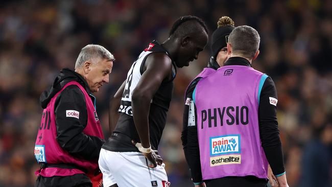 Aliir Aliir is taken from the ground after a big collision with Lachie Jones. Picture: Sarah Reed/AFL Photos via Getty Images