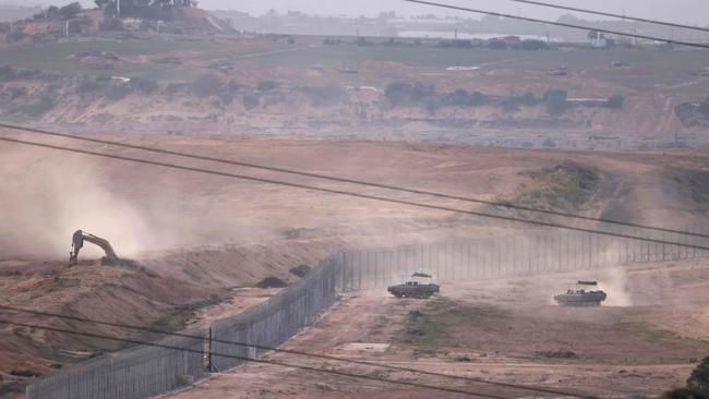 In southern Israel along the border with the Gaza Strip, Israeli army buldozers and tanks cross  into Gaza on Sunday. Picture: Menahem Kahana  / AFP