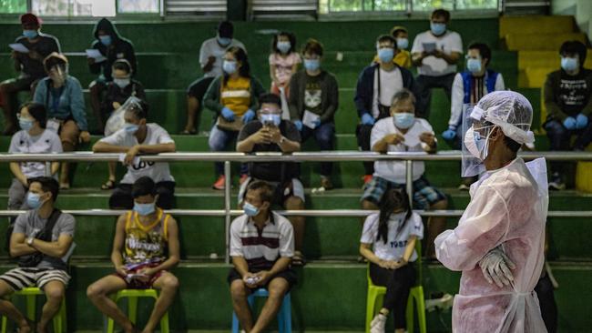 Manila residents queue for free COVID-19 swab testing at a basketball court in Metro Manila’s Navotas city. Picture: Getty Images