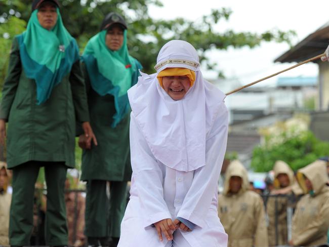 A Muslim woman cries out as she gets caned for being caught in proximity with a male in Banda Aceh on October 17, 2016. Indonesia's Aceh province has gained international infamy for its strict Islamic laws. Picture: AFP