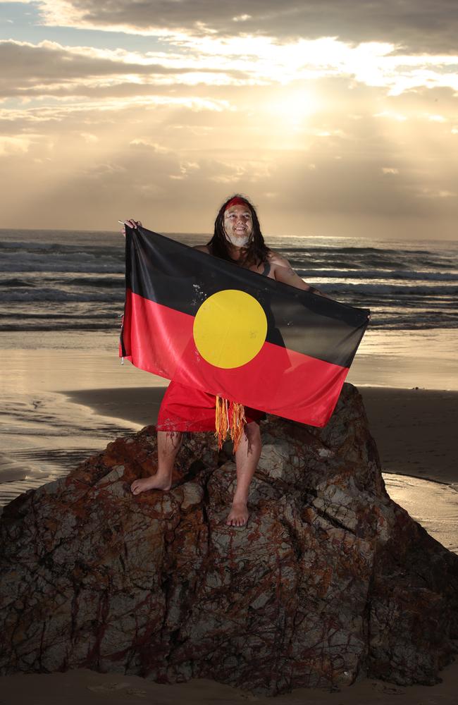 Aboriginal dancer Goompi Ugerabah with the Aboriginal flag on Miami Beach. Picture: Glenn Hampson