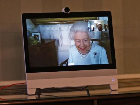 The Queen speaks via Zoom to diplomats visiting Buckingham Palace. In the far left corner, a never before seen photo of Prince George and Princess Charlotte is featured. Picture: Supplied