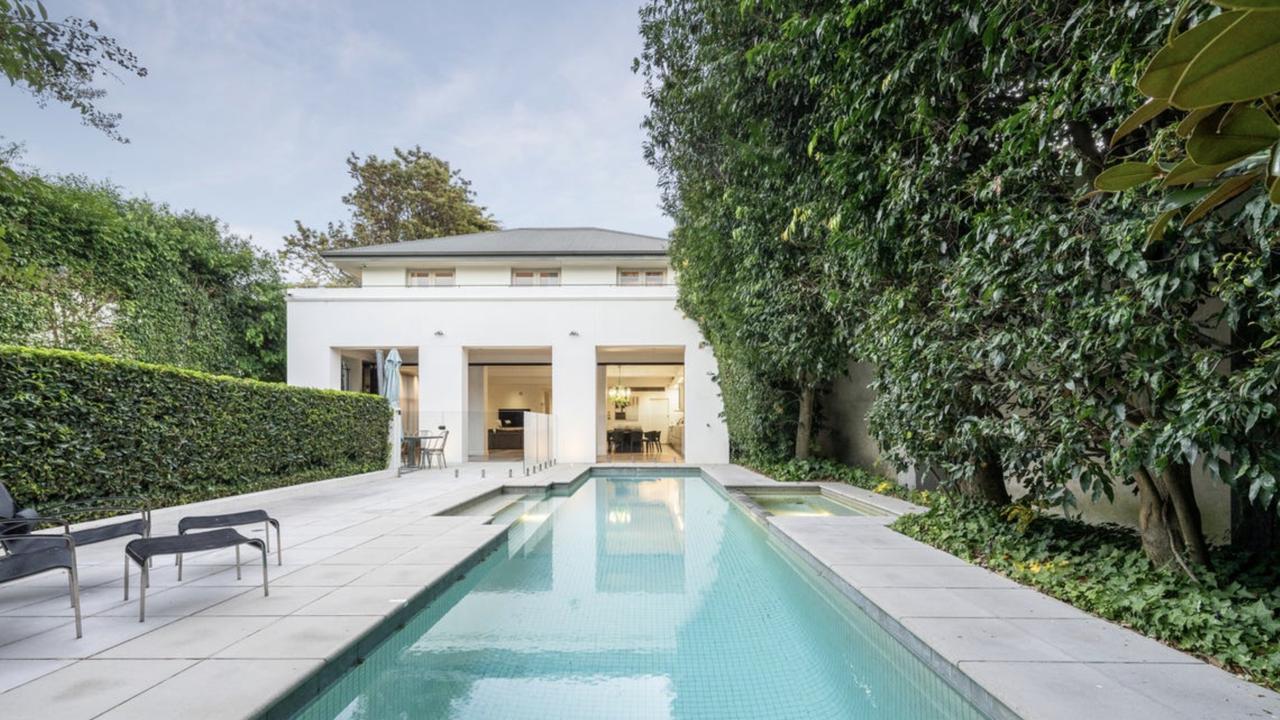 The private lap pool is surrounded by lush landscaping, a firepit, and space for entertaining — perfect for families.