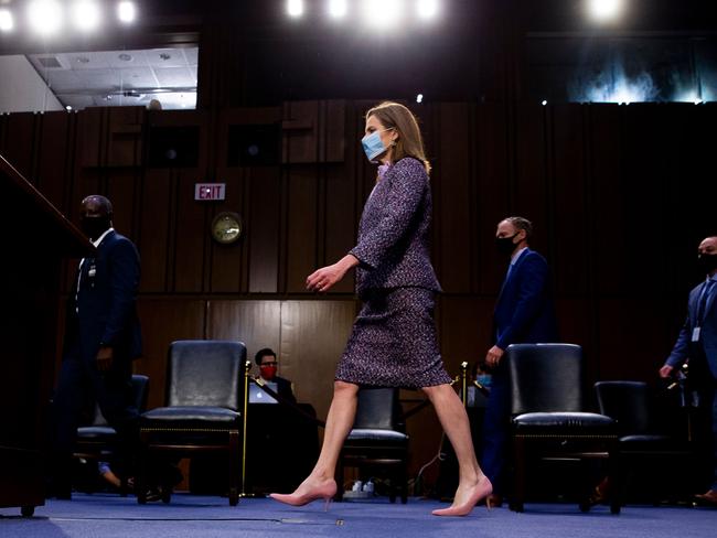 TOPSHOT - Supreme Court nominee Judge Amy Coney Barrett (C) returns from a break in her confirmation hearing before the Senate Judiciary Committee in the Hart Senate Office Building in Washington, DC, on October 14, 2020. - After liberal icon Ruth Bader Ginsburg's death last month left the nine-member court with a vacancy, Trump has rushed to fill it at the height of his presidential election battle against Democrat Joe Biden. (Photo by MICHAEL REYNOLDS / POOL / AFP)