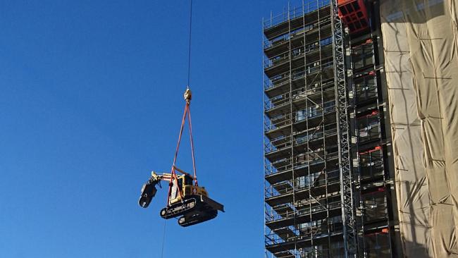 An excavator being lifted to the top of 10 Murray St this morning as demolition work continues. Picture: REBECCA SPRY