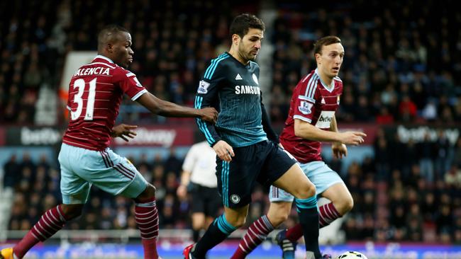 Cesc Fabregas of Chelsea is challenged by Enner Valencia and Mark Noble.