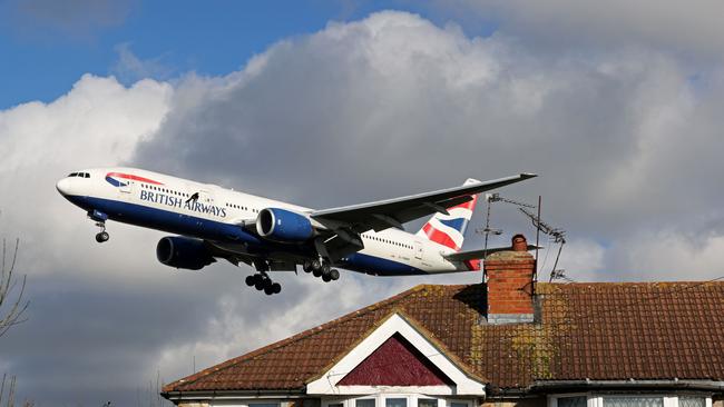 A British Airways Boeing 777-236 aircraft flies over residential houses as it prepares to land at London’s Heathrow Airport. Picture: AFP