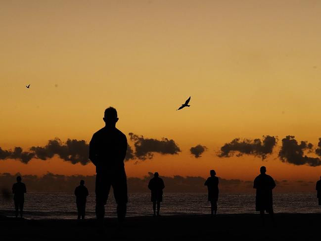 People commemorate Anzac Day at dawn on beaches on the east coast. Picture: AAP Image/Dave Hunt