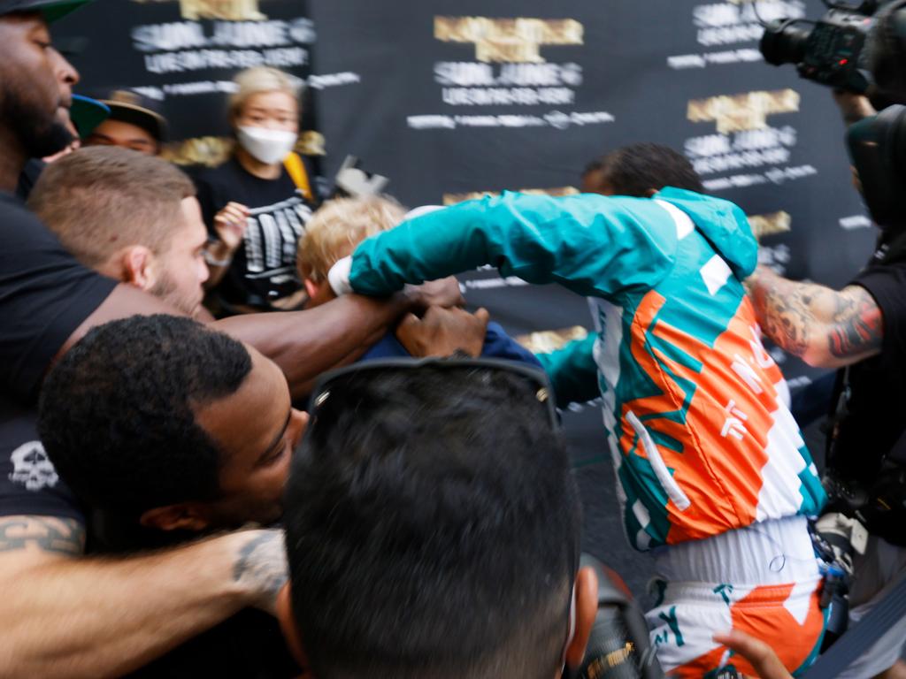 Floyd Mayweather appears to swing at Jake Paul. (Photo by Cliff Hawkins/Getty Images)