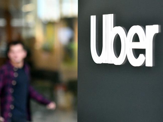 (FILES) An Uber logo is seen on a sign outside the company's headquarters location as people protest nearby in San Francisco, California on May 8, 2019. Ride-hailing giant Uber on February 7, 2024 reported its first annual net profit since the company went public in 2019. Uber booked a net profit of $1.9 billion in 2023, compared with a loss of $9.1 billion in 2022, according to a statement. (Photo by Josh Edelson / AFP)