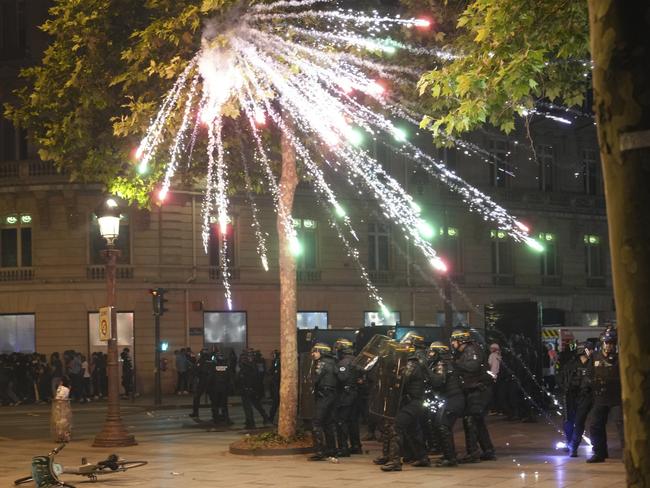 Fireworks explode over riot police on the Champs-Elysees. Picture: Aurelien Morissard/AP