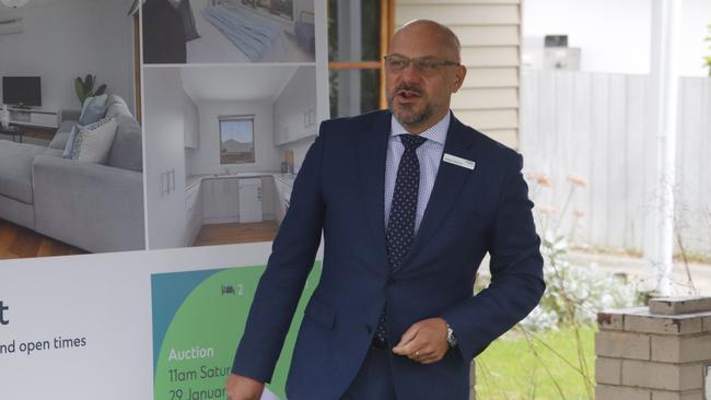 Compton Green auctioneer Adrian Butera calls for bids at 1/16 Herbert St, Belmont. Agent Emilly Simmonds looks on.