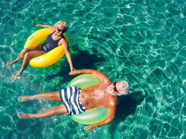 ESCAPE: Advice Old Insurance, Sarah Nicholson.  Photo of a senior couple floating in the ocean in an inflatable rings and enjoying the best years of their lives . Picture: iStock