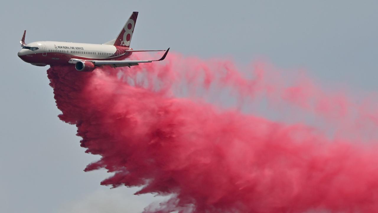 A NSW Rural Fire Service plane drops fire retardent on an out-of-control bushfire near Taree. Picture: AFP