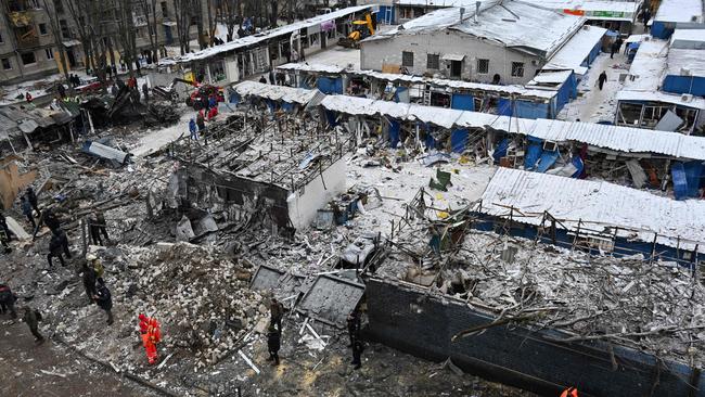 Ukrainian rescue workers clear the debris from destroyed market buildings following a missile attack in Kharkiv. Picture: AFP