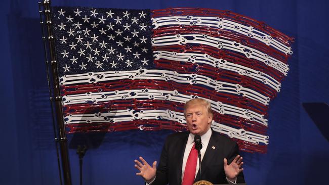 US President Donald Trump speaks to workers at tool manufacturer Snap-On in Wisconsin with a US flag made out of spanners in th background. Picture: Getty