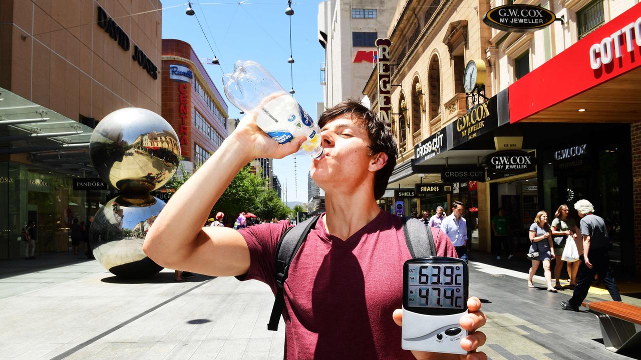 Zac Martin-Peddey from Semaphore takes a drink while showing ground paver temperature at over 63 degrees and the air temperature over 47 degrees at 1.30pm in Rundle Mall. Picture: Mark Brake