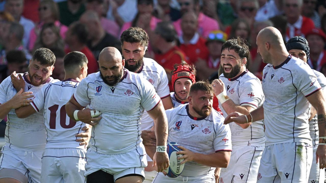 Georgia’s hooker Vano Karkadze (C) celebrates with teammates after scoring a try. (Photo by LOIC VENANCE / AFP)