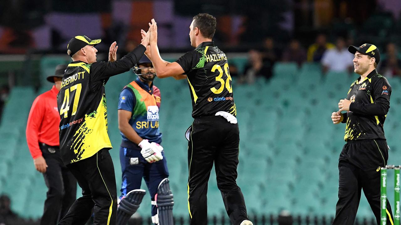 Australia's Josh Hazlewood (C) celebrates his wicket of Sri Lanka's batsman Chamika Karunaratne with teammates during the first T20 international cricket series match between Australia and Sri Lanka at the Sydney Cricket Ground (SCG) on February 11, 2022, in Sydney. (Photo by Muhammad FAROOQ / AFP) / -- IMAGE RESTRICTED TO EDITORIAL USE - STRICTLY NO COMMERCIAL USE --