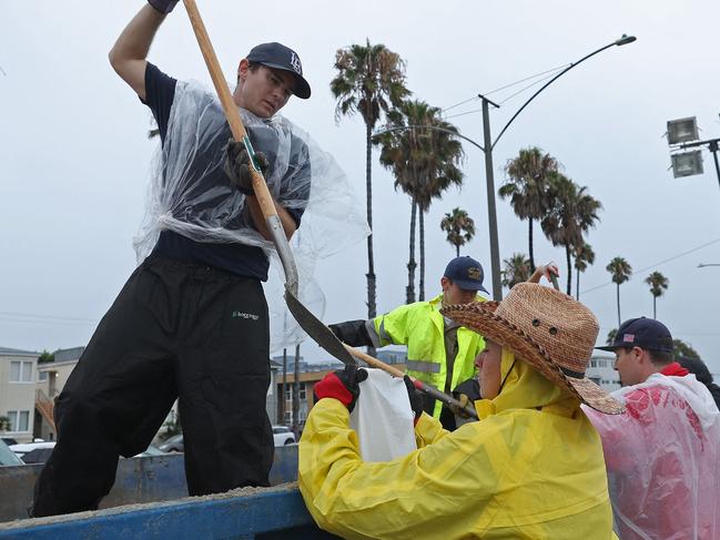 Volunteers and members of the Long Beach Fire Department fill sandbags in Long Beach. Pictures: AFP/Getty Images