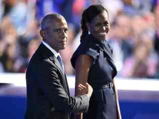 TOPSHOT - Former US President Barack Obama and his wife and former First Lady Michelle Obama stand on stage after she introduced him on the second day of the Democratic National Convention (DNC) at the United Center in Chicago, Illinois, on August 20, 2024. Vice President Kamala Harris will formally accept the partyâs nomination for president at the DNC which runs from August 19-22 in Chicago. (Photo by ANDREW CABALLERO-REYNOLDS / AFP)