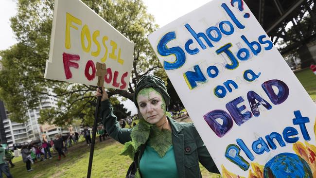 A protester holds up signs during the Climate Strike at the Domain. Picture: Getty