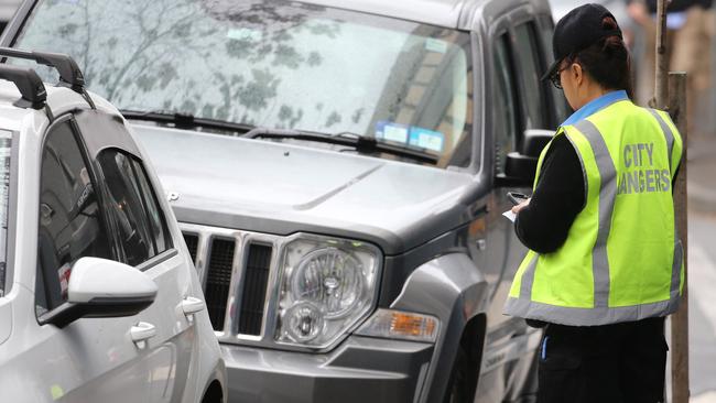 A city of Sydney parking inspector books a car on Cooper St, Surry Hills. Picture: John Grainger