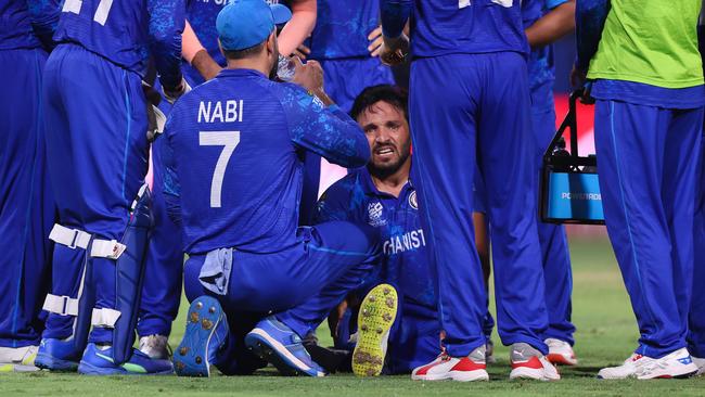 ST VINCENT, SAINT VINCENT AND THE GRENADINES - JUNE 22: Gulbadin Naib of Afghanistan goes down with an injury whilst celebrating with teammates after bowling Pat Cummins of Australia (not pictured) during the ICC Men's T20 Cricket World Cup West Indies & USA 2024 Super Eight match between Afghanistan and Australia at Arnos Vale Ground on June 22, 2024 in St Vincent, Saint Vincent and The Grenadines. (Photo by Darrian Traynor-ICC/ICC via Getty Images)