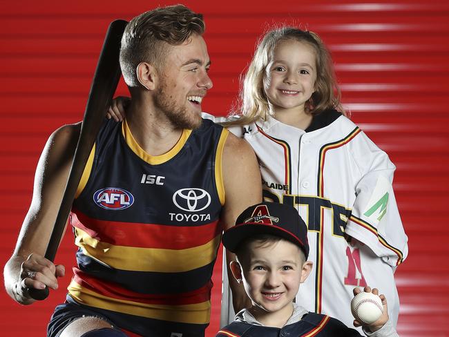 04/06/18 - Adelaide Crows join forces with the Adelaide Bite baseball club - Hugh Greenwood with baseball fans Jordan Versace 7yrs and Evelyn Versace 5yrs. Picture SARAH REED