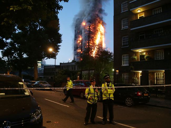 In this photo taken on June 14, 2017 police form a security cordon as a huge fire engulfs the Grenfell Tower in west London. Picture: Daniel Leal-Olivas/AFP