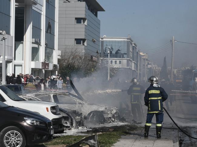 Firefighters hose down the luxury vehicle, which is understood to have exploded when he turned the ignition key. Picture: News Corp Australia