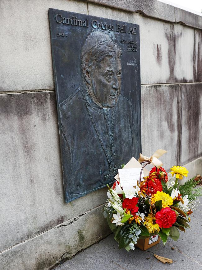 A floral tribute left at the plaque of George Pell at St Mary’s Cathedral in Sydney. Picture: Richard Dobson